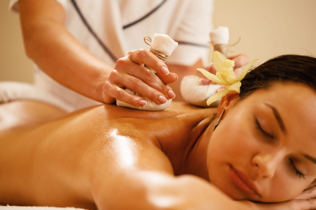close up of woman receiving thai herbal compress massage at the spa.